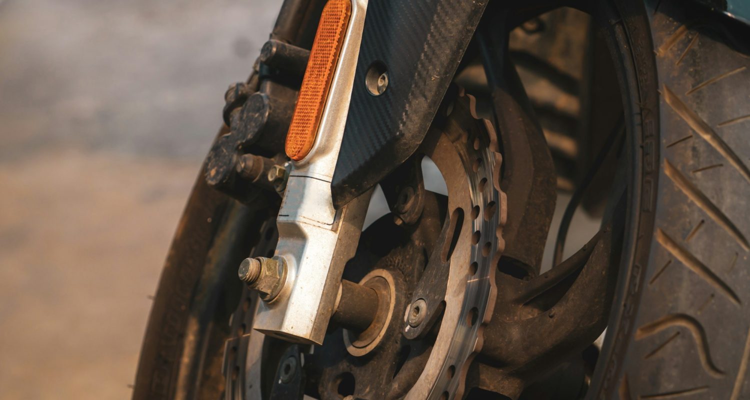 Closeup disc brake of motorcycle. Motorbike accessory. Aluminum alloy wheel of dirty motorcycle.