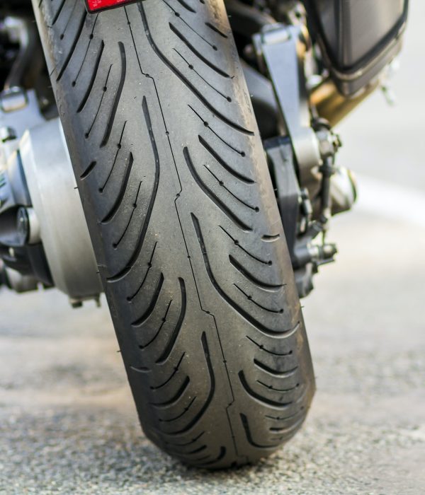 Rear wheel of sports motorcycle on road. Motorbike parked on a street. Freedom and travel concept.